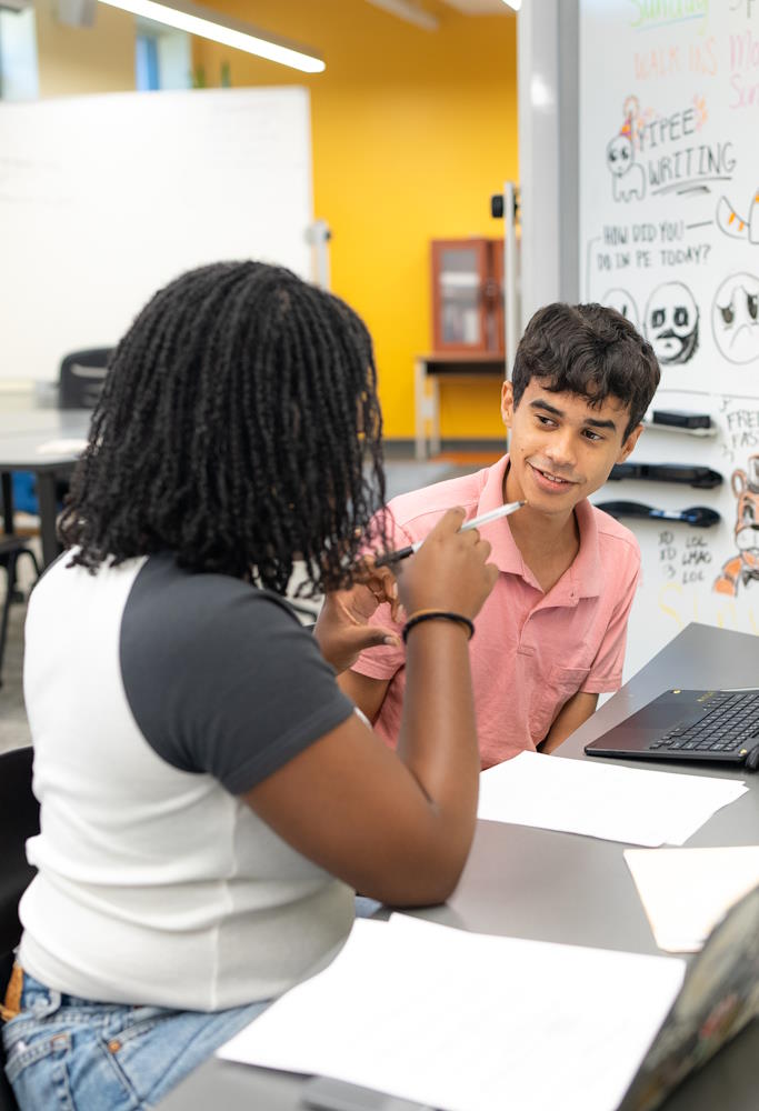 someone teaching at a blackboard in front of students