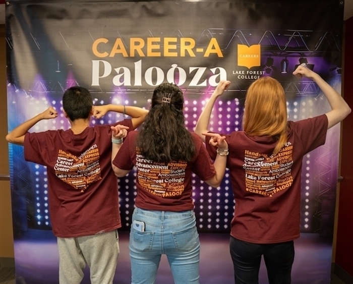 Three students with backs to camera showing T-shirts