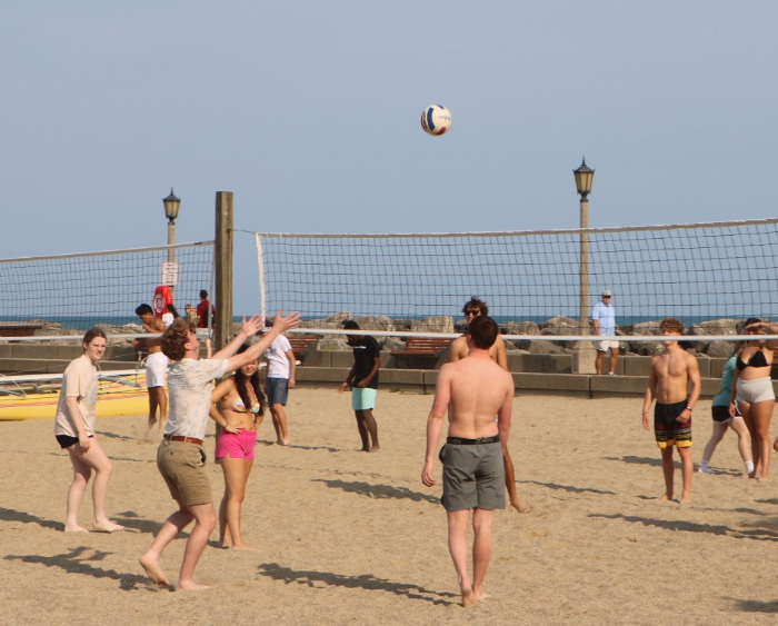 students play volleyball on the beach