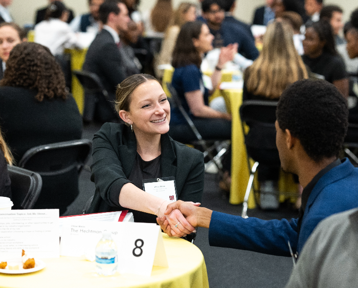 student and professional shake hands at speed networking
