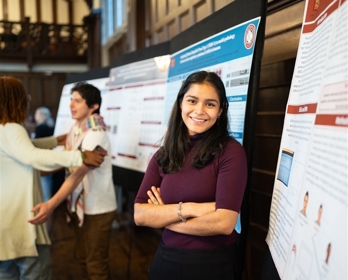 Student in front of scientific poster board