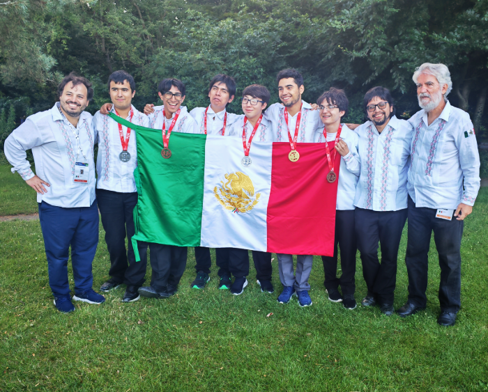 students and trevino pose with the flag of mexico