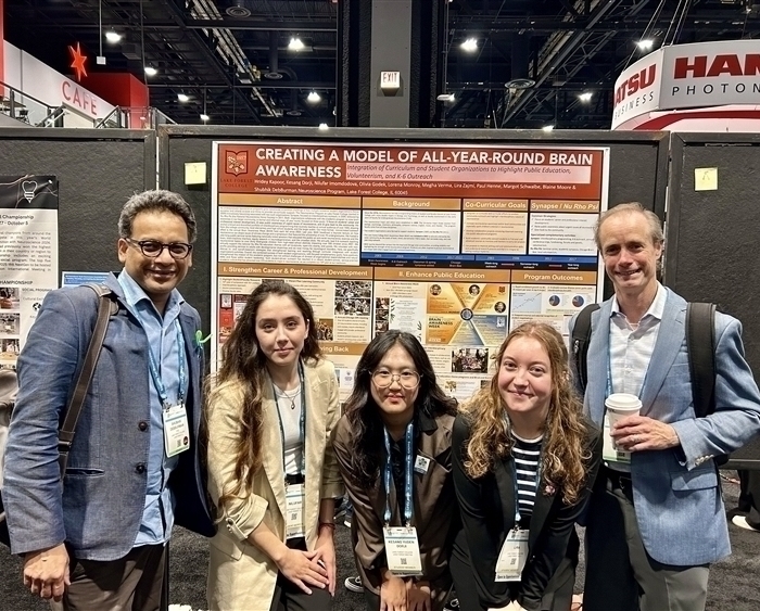 three students and two professors in front of research poster